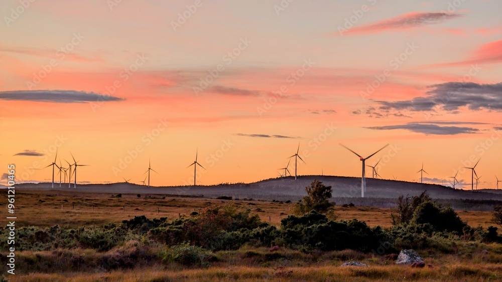 Wind turbines on wind farm under beautiful orange sunset sky at Galway, Ireland, green energy, environment, nature background
