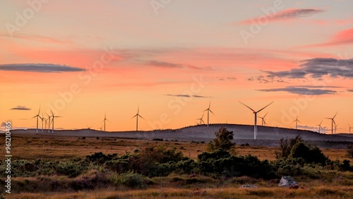 Obraz na płótnie Wind turbines on wind farm under beautiful orange sunset sky at Galway, Ireland, green energy, environment, nature background w salonie