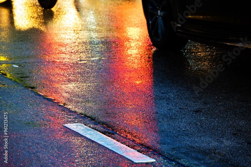 A wet road with a white line on it. The line is barely visible