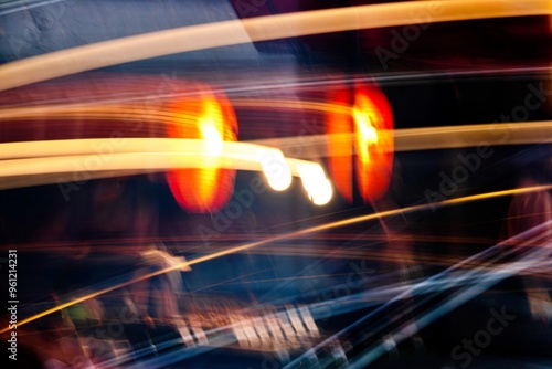 A blurry image of a car with three red lights. The lights are lit up and the image is in black and white