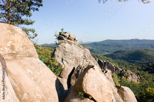 A unique rock formation stands tall against a clear blue sky.