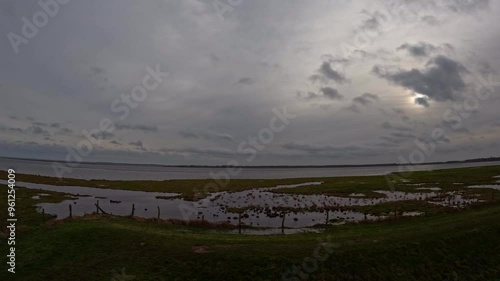 time lapse moving clouds cloudy day with swamp foreground near Greifswald, Mecklenburg western pomerania and baltic sea background. photo