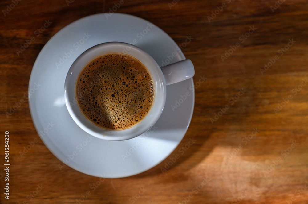A cup of coffee on wooden table A cup of coffee on wooden table