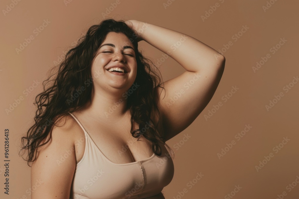 A joyful plus size woman radiates confidence in beige lingerie while posing happily in a studio setting A joyful plus size woman radiates confidence in beige lingerie while posing happily in a studio setting
