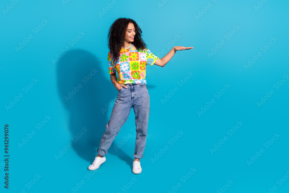 Full length photo of shiny attractive lady dressed flower print t-shirt showing empty space isolated blue color background Full length photo of shiny attractive lady dressed flower print t-shirt showing empty space isolated blue color background