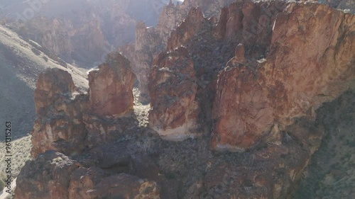 Drone fast fly over rock formations at Leslie Gulch Oregon to reveal canyon and windy dirt road photo