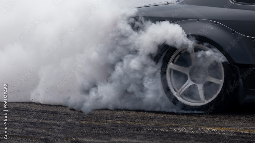 White smoke from tire, Car burnout wheels tire with white smoke,Car wheel burnout with smoke from the spinning tyre, Drag car wheel burns tires preparation for the race.