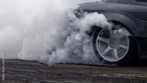 Obraz na płótnie White smoke from tire, Car burnout wheels tire with white smoke,Car wheel burnout with smoke from the spinning tyre, Drag car wheel burns tires preparation for the race. w salonie
