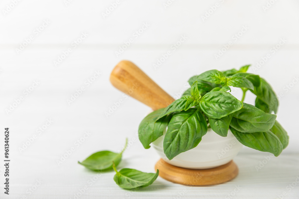 Fresh green basil in a mortar on a textured wooden background. Organic spices and herbs. Vegan. Fresh kitchen herbs. Fresh basil being made into pesto with mortar and pestle.Copy space. Place for text Fresh green basil in a mortar on a textured wooden background. Organic spices and herbs. Vegan. Fresh kitchen herbs. Fresh basil being made into pesto with mortar and pestle.Copy space. Place for text