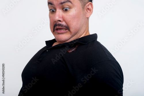 A middle aged man horrified at a cockroach crawling on his shirt. Funny scene with an exaggerated scared reaction. Set against a white background. photo