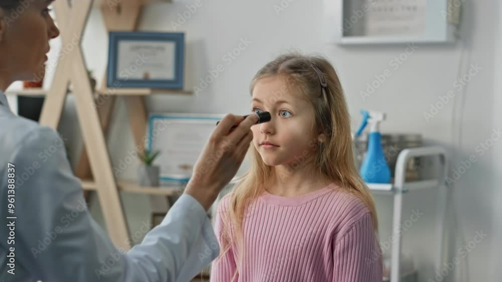 Pediatrician testing kid eyes reflexes during checkup. Closeup cute blond girl Pediatrician testing kid eyes reflexes during checkup. Closeup cute blond girl