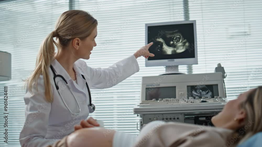 Gynecologist performing sonogram examination closeup. Happy doctor showing baby Gynecologist performing sonogram examination closeup. Happy doctor showing baby