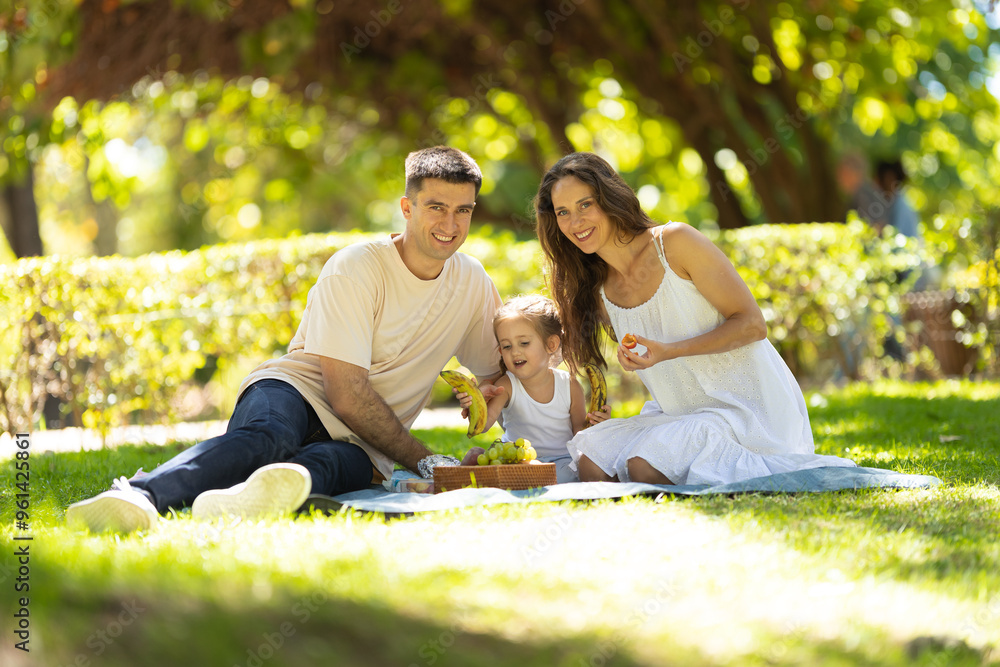 Happy family having fun, enjoying picnic in park on summer day Happy family having fun, enjoying picnic in park on summer day