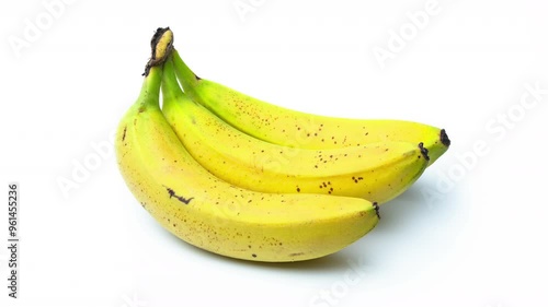 Time lapse video of three bananas ripening on a white background, from green to ripe yellow with brown spots.