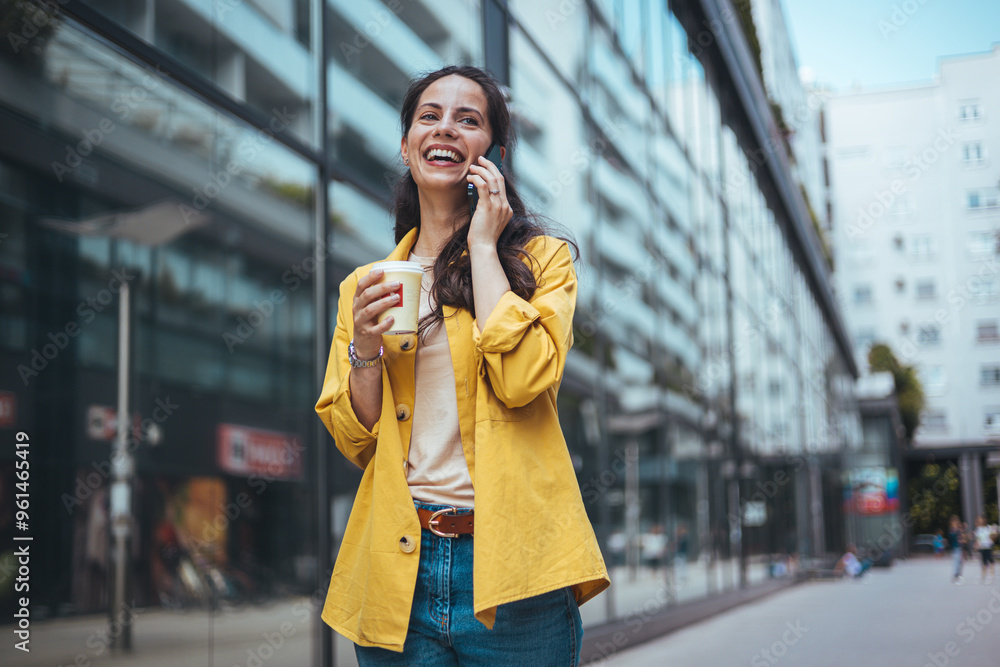 Fototapeta premium Happy Woman Talking on Phone Holding Coffee Outdoors