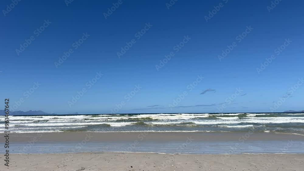 Beach rolling waves blue waters and blue skies Beach rolling waves blue waters and blue skies
