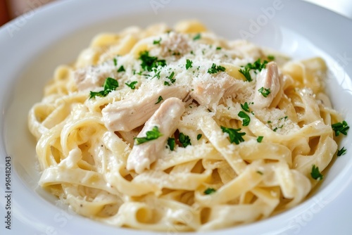 A creamy chicken Alfredo pasta with fettuccine, garnished with parsley and Parmesan