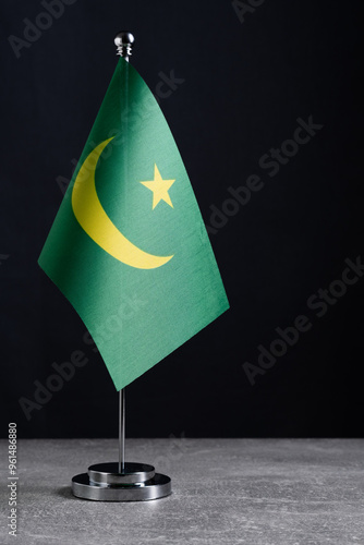 Mauritania flag on a metal flagpole on a black background. photo