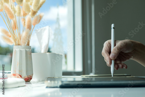 Hand using digital stylus writing on tablet. Concept of digital signature Signing documents electronically via tablet or taking notes electronic
