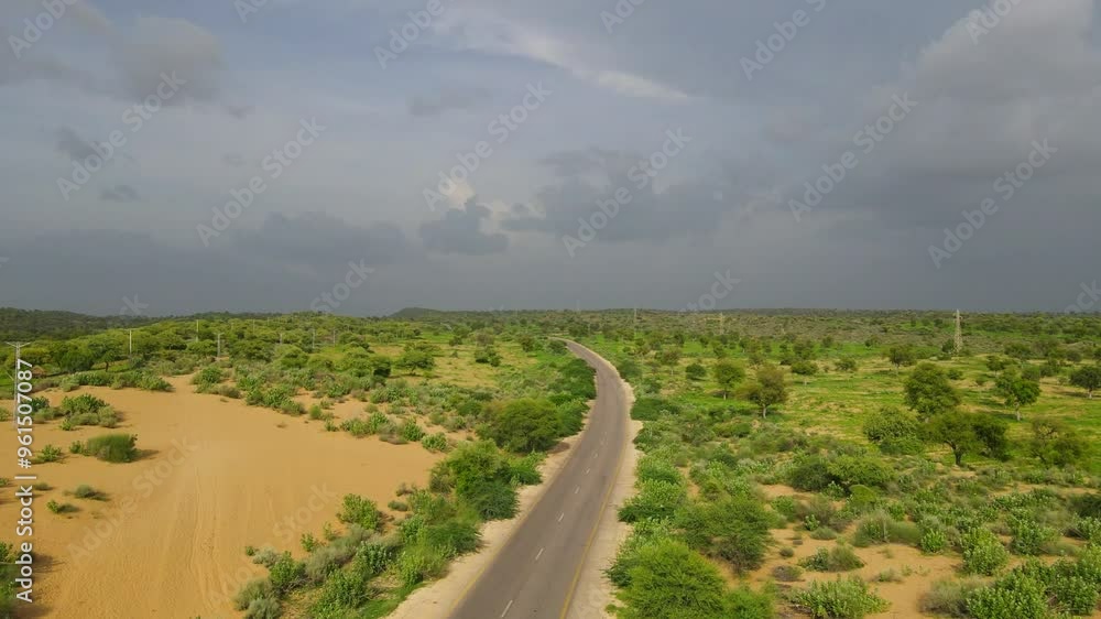 Aerial view of remote road with dynamic clouds in rainy season Aerial view of remote road with dynamic clouds in rainy season