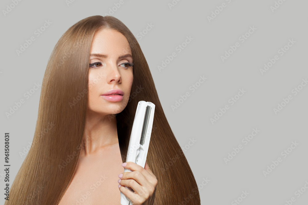 Beauty portrait of fashion model woman using hair straighteners iron on white background. Harstyle, hair care, beauty salon and treatment concept Beauty portrait of fashion model woman using hair straighteners iron on white background. Harstyle, hair care, beauty salon and treatment concept