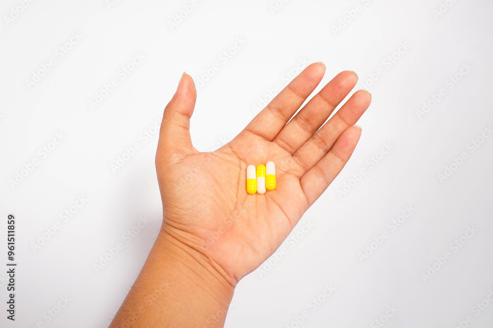 a man consuming three yellow capsules with white isolated a man consuming three yellow capsules with white isolated