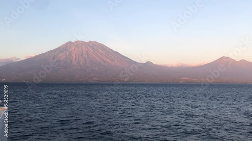 epic active volcanic Mount Agung with goldern sunrise. view shot from the sea