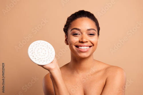 Photo of gorgeous cheerful woman hold massager bodycare routine naked shoulders isolated on beige pastel color background photo