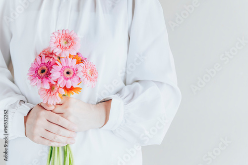 ガーベラの花束を持つ女性