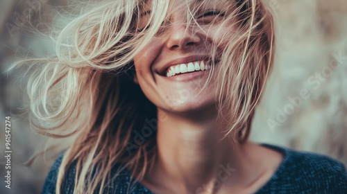 Joyful Woman with Windswept Hair and Radiant Smile in Natural Light