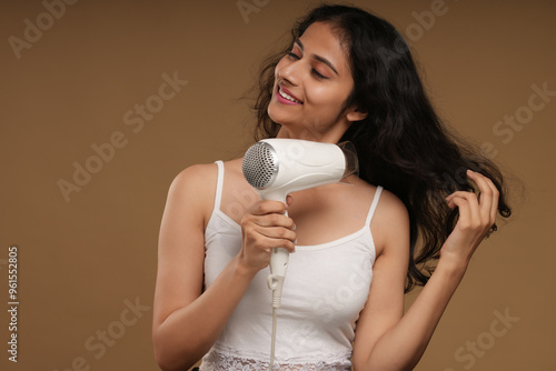 young woman using hair dryer 