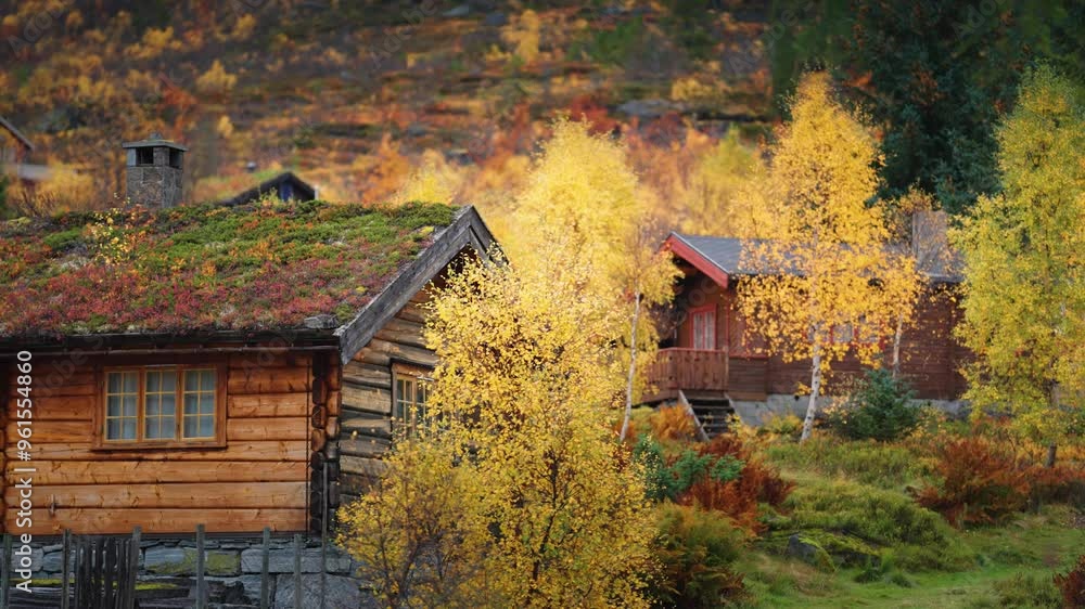 Several small wooden cabins with stone foundations and sod roofs stand surrounded by the autumn landscape at the foot of the mountain. Several small wooden cabins with stone foundations and sod roofs stand surrounded by the autumn landscape at the foot of the mountain.