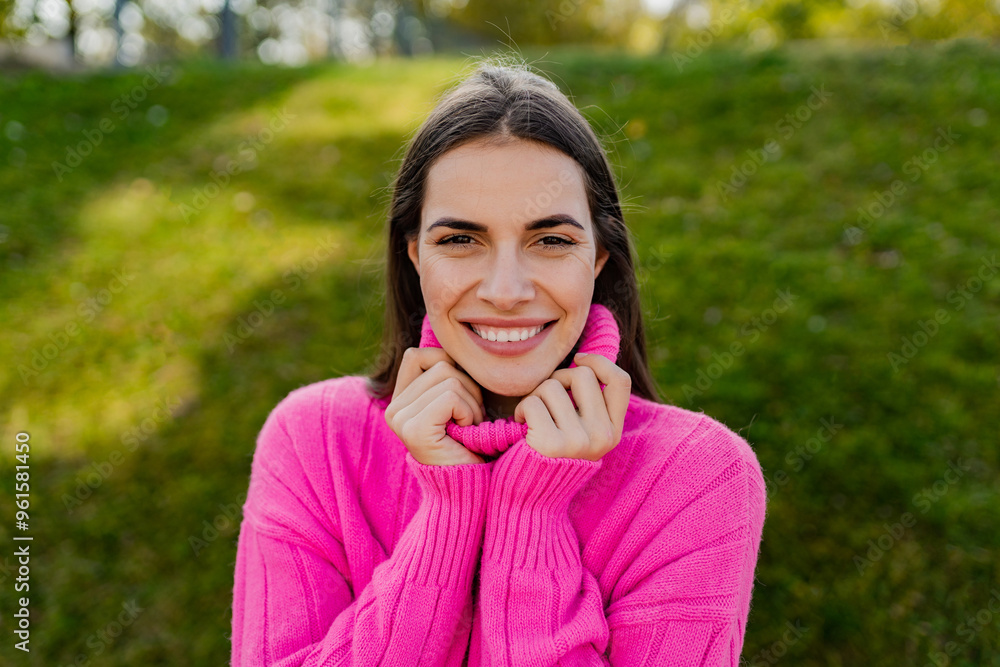 young smiling woman in pink sweater walking in green park young smiling woman in pink sweater walking in green park