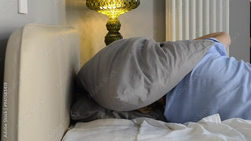 Depressed woman lying in bed covered with pillow. Emotional experiences ...