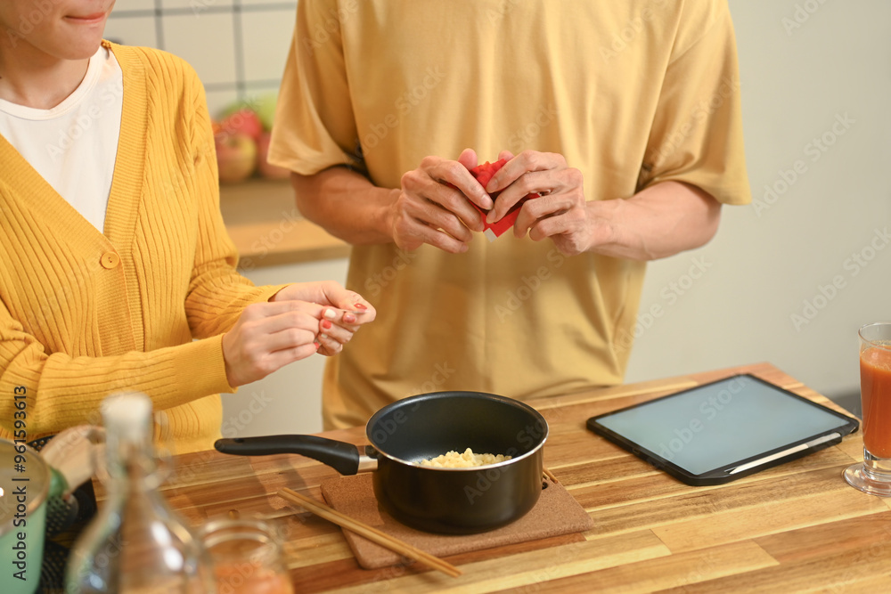Cropped shot of young couple enjoying a casual meal of instant noodles together in their kitchen Cropped shot of young couple enjoying a casual meal of instant noodles together in their kitchen