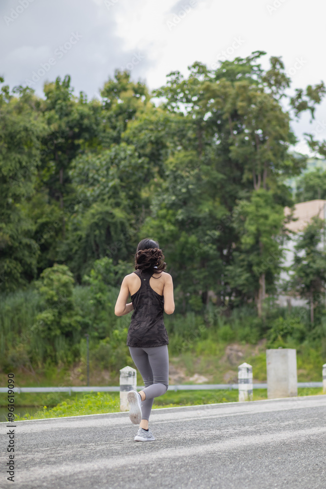 young Asian woman wears sports bra and running shoes to go jogging every morning for her health because running can help her body burn extra energy. Health running concept for the body. young Asian woman wears sports bra and running shoes to go jogging every morning for her health because running can help her body burn extra energy. Health running concept for the body.