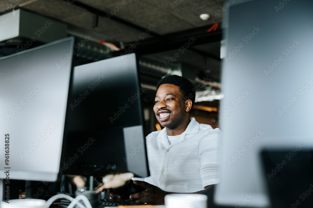 Smiling programmer working on desktop PC at tech startup office Smiling programmer working on desktop PC at tech startup office