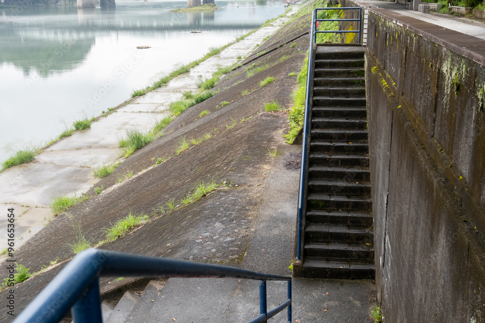 A set of concrete stairs with a metal railing leading down to an ...