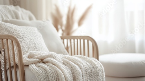 A minimalist wooden chair paired with a knitted throw and fluffy pillows, set against a bright, airy background, creating a calming and elegant living space.