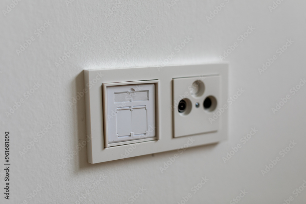 Close Up of White Light Switch and Outlet on a White Wall Close Up of White Light Switch and Outlet on a White Wall