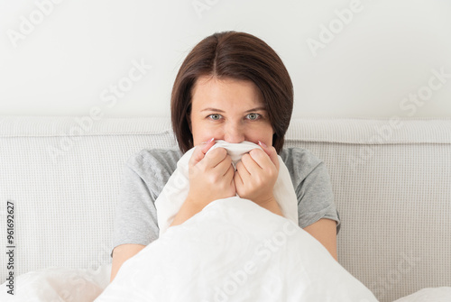 young woman sitting in bed and is scared and terrified