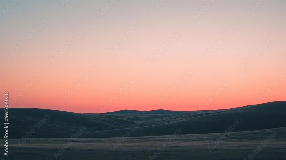 Obraz premium A tranquil countryside scene at sunset, with rolling hills under a sky painted in shades of pink and orange