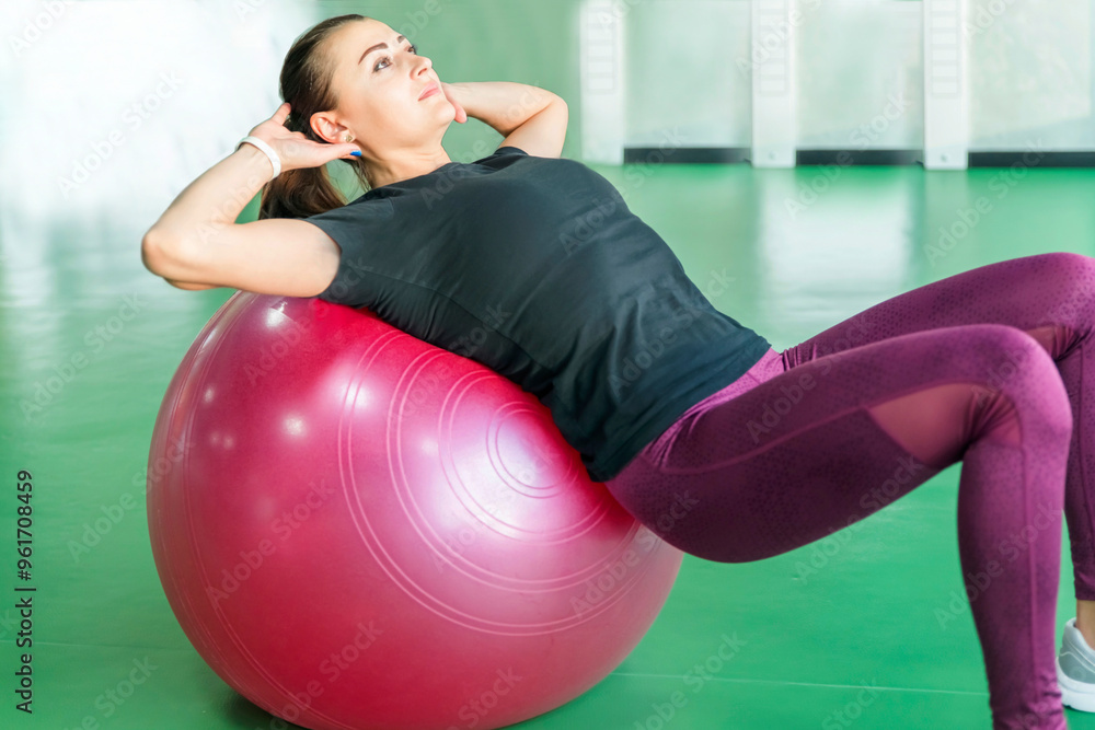 Woman at the gym doing exercises with pilates ball on her back Woman at the gym doing exercises with pilates ball on her back
