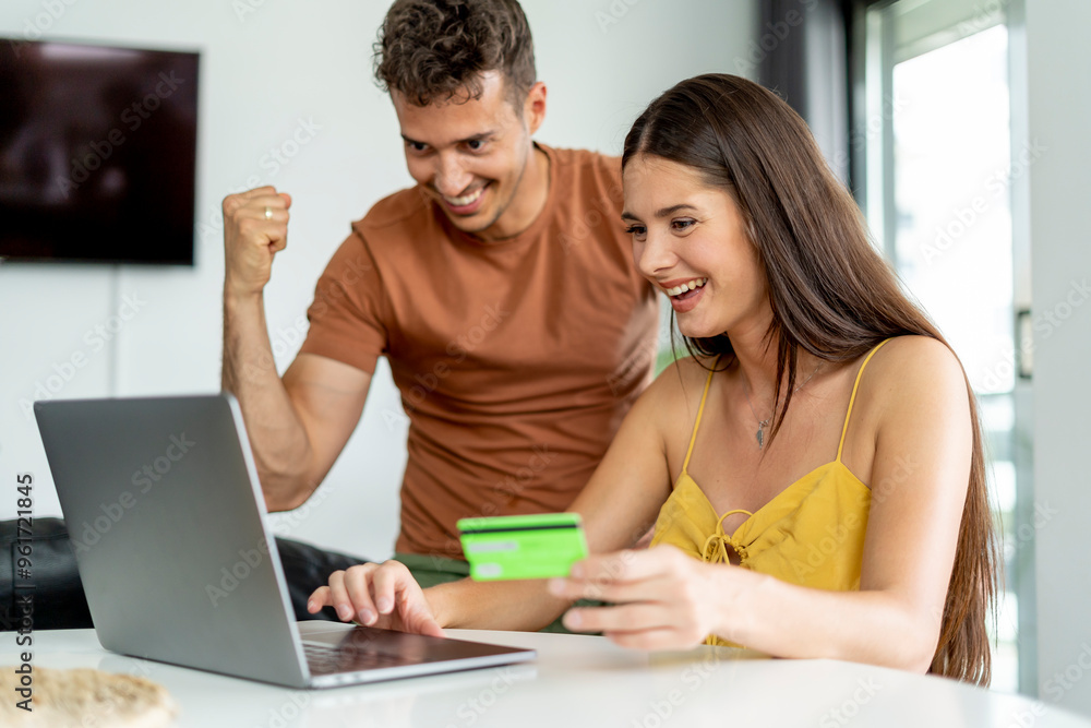 Excited couple celebrating successful online purchase. Excited couple celebrating successful online purchase.