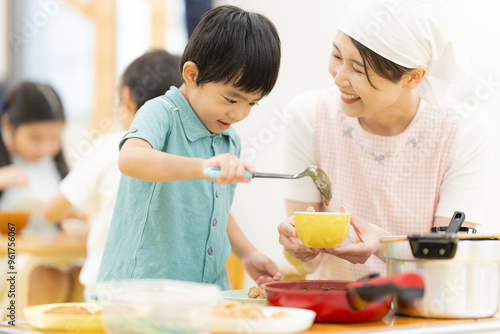 Bild auf Leinwand 給食をよそう4歳の男の子