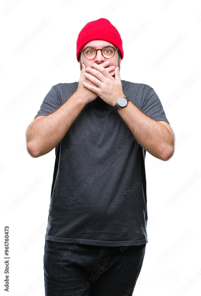 Naklejka premium Young caucasian hipster man wearing glasses over isolated background shocked covering mouth with hands for mistake. Secret concept.