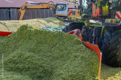 Obraz na płótnie Traktor auf einer Maissilage während der Maisernte w salonie