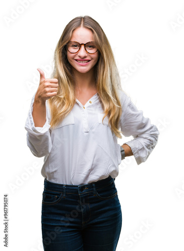 Young beautiful blonde business woman wearing glasses over isolated background doing happy thumbs up gesture with hand. Approving expression looking at the camera with showing success.