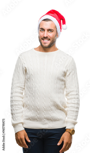 Young handsome man wearing santa claus hat over isolated background looking away to side with smile on face, natural expression. Laughing confident.