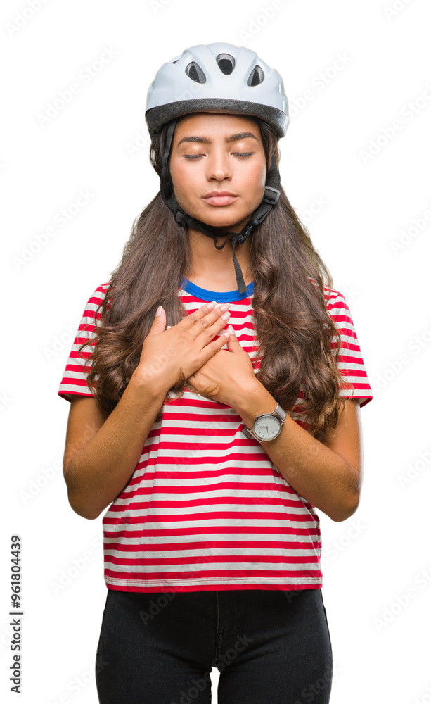 Young arab cyclist woman wearing safety helmet over isolated background smiling with hands on chest with closed eyes and grateful gesture on face. Health concept. Young arab cyclist woman wearing safety helmet over isolated background smiling with hands on chest with closed eyes and grateful gesture on face. Health concept.